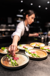 A chef is plating dishes for the guests